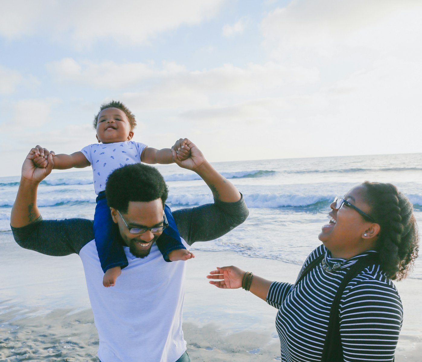 woman in black and white striped long sleeve shirt carrying girl in blue and white dress: Family Therapy