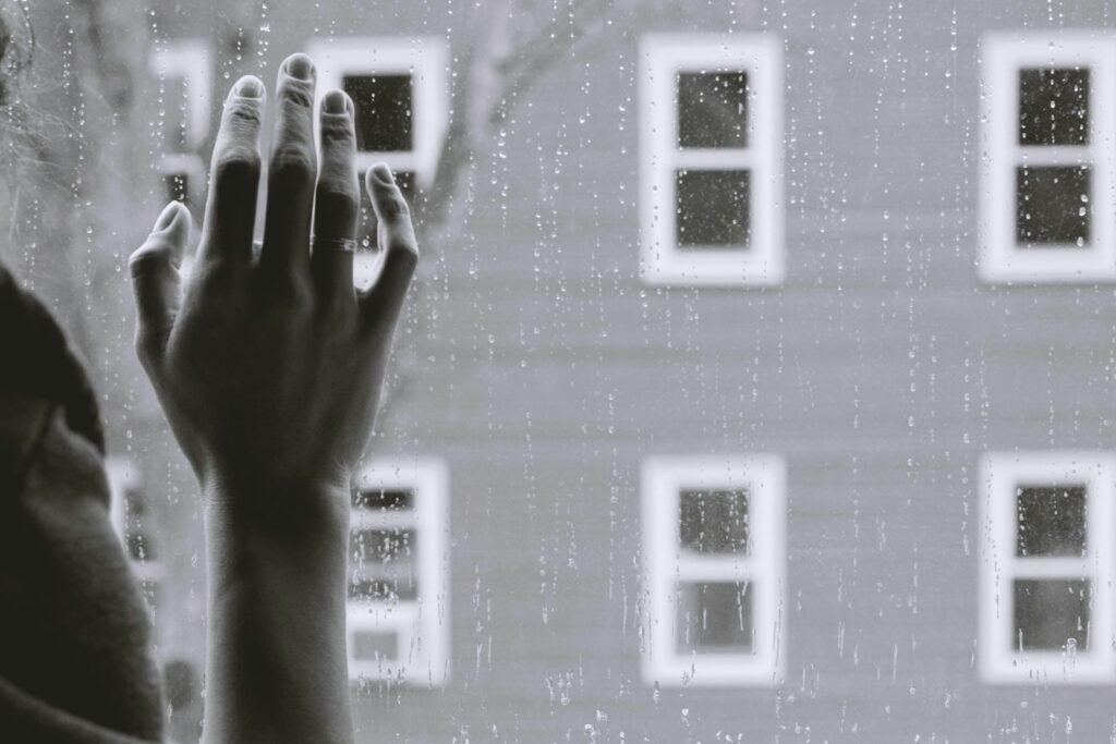 grayscale photo of woman right hand on glass: Grief Therapy