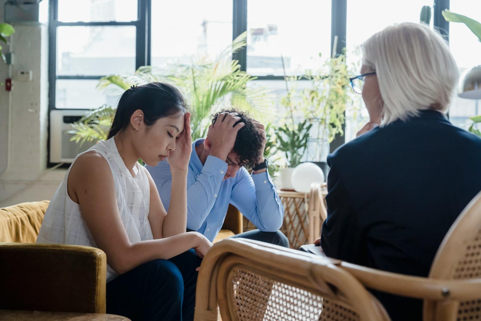 Young couple experiencing stress during a counseling session in a modern office setting.